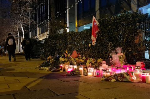 Blumen und Kerzen stehen auf einem Bürgersteig in München