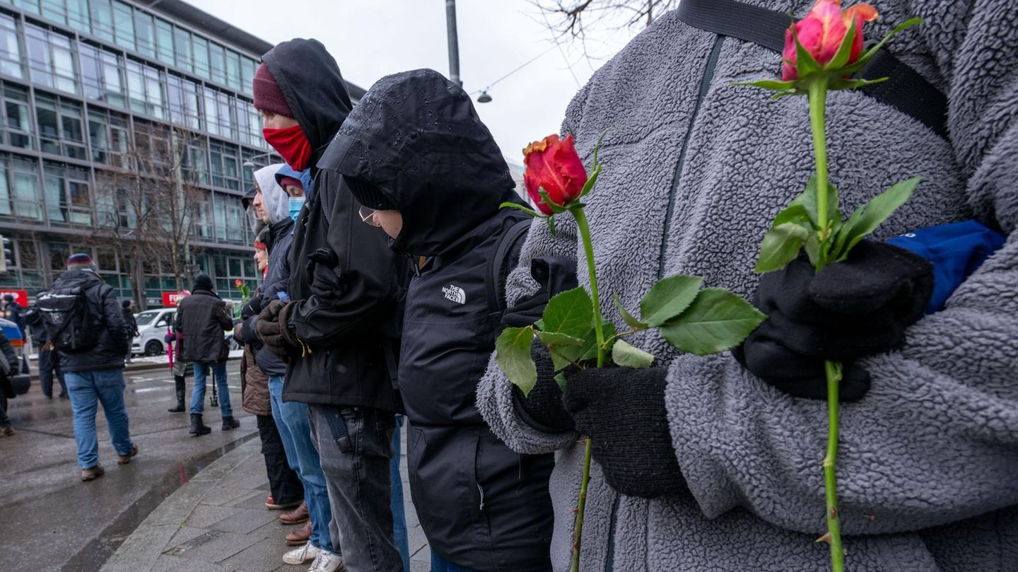 Frauen und Männer bilden eine Menschenkette um den Gedenkort für die Opfer des Anschlags in München