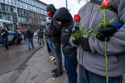 Frauen und Männer bilden eine Menschenkette um den Gedenkort für die Opfer des Anschlags in München