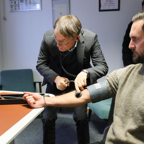 Karl Lauterbach misst Blutdruck bei einem Patienten