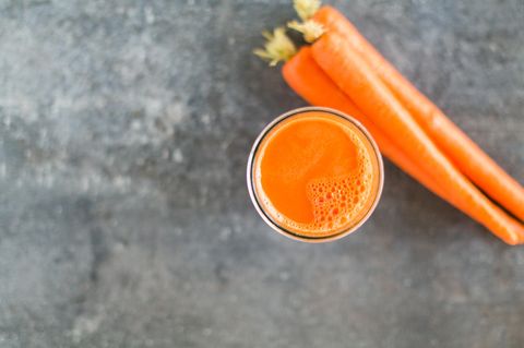 Ein Glas Karottensaft und ein paar frische Karotten