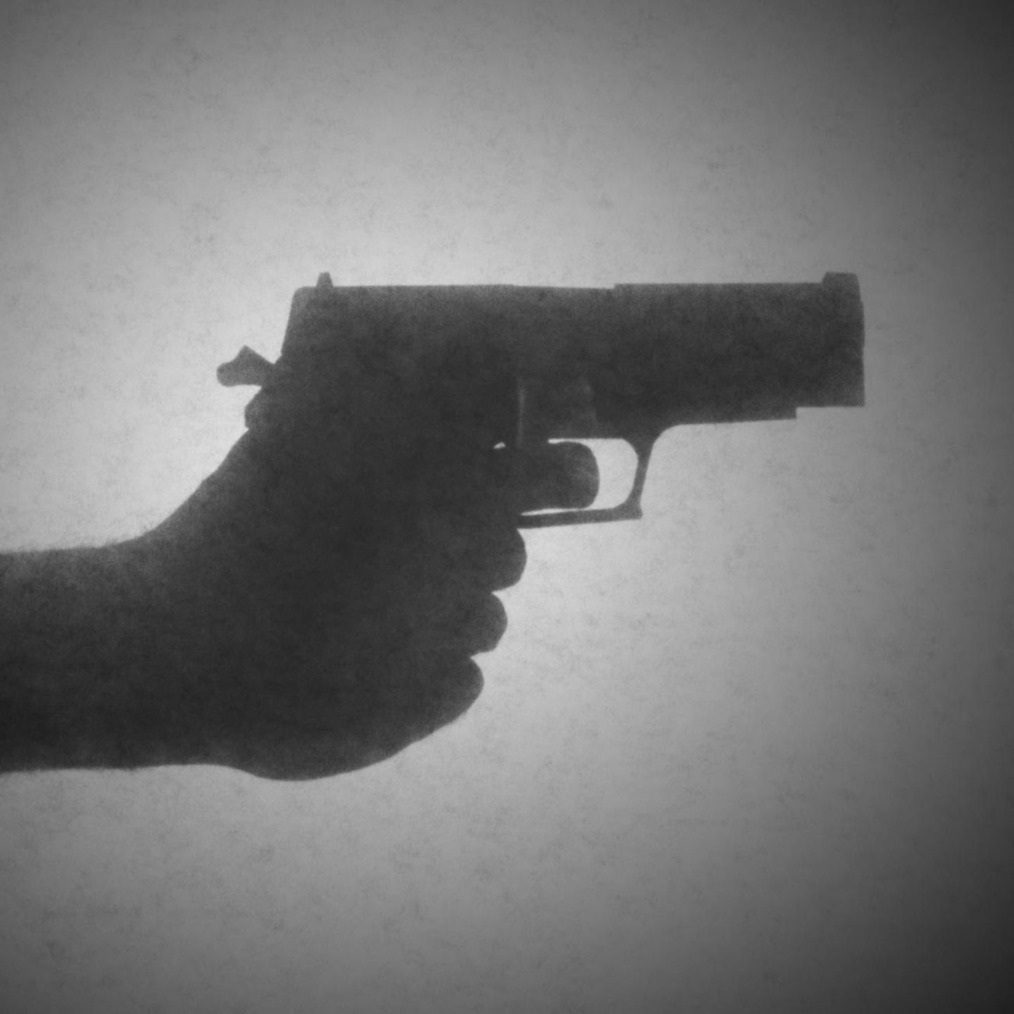 Schattenriss einer Hand, die eine Pistole hält