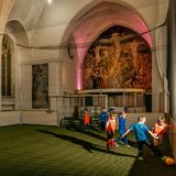 Kinder spielen in einer Kirche Fußball.