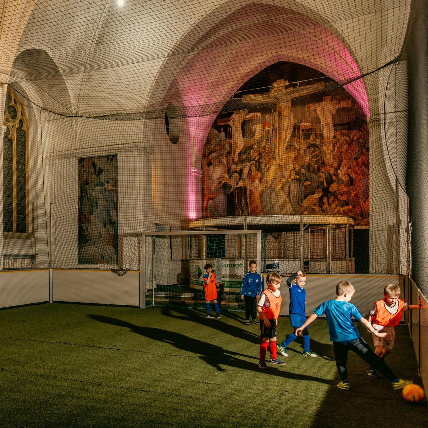 Kinder spielen in einer Kirche Fußball.