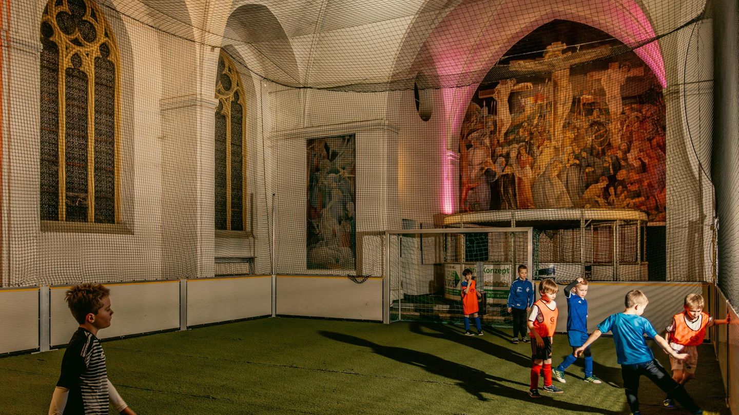 Kinder spielen in einer Kirche Fußball.