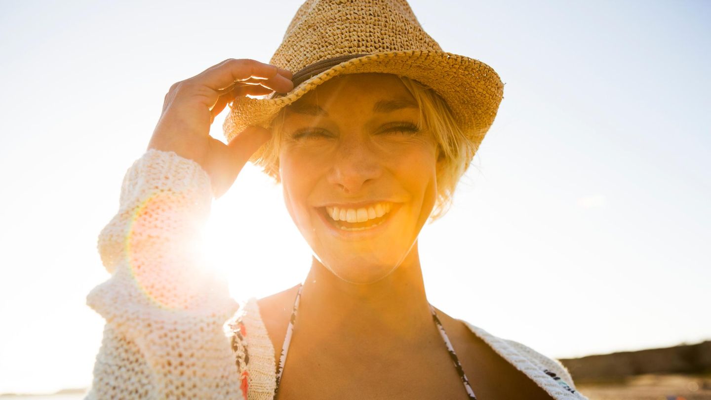 Urlaubsgeld: Fröhliche Urlauberin mit der Sonne im Rücken