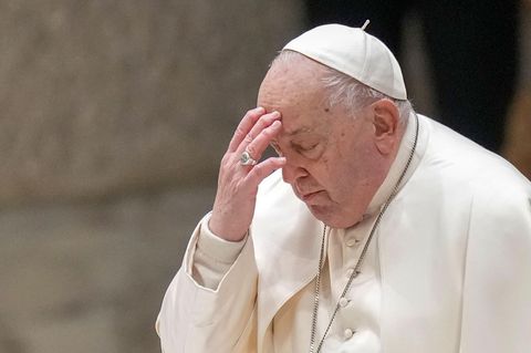 Papst Franziskus bekreuzigt sich und berührt dabei seine Stirn mit der linken Hand