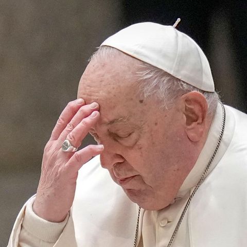 Papst Franziskus bekreuzigt sich und berührt dabei seine Stirn mit der linken Hand