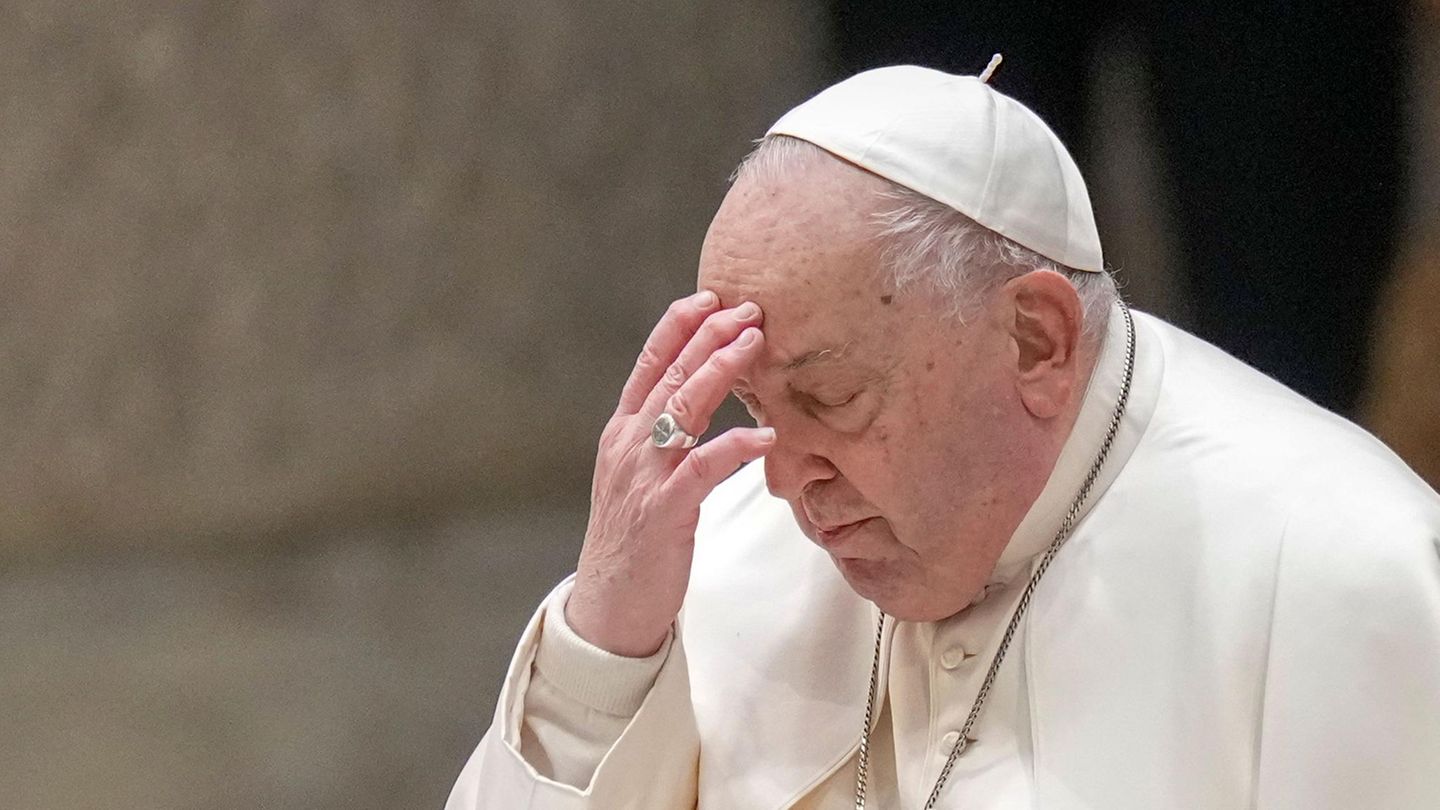 Papst Franziskus bekreuzigt sich und berührt dabei seine Stirn mit der linken Hand