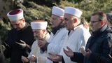 Gemeinsam mit Imamen beten während der Gedenkfeier für die Opfer des Anschlags Hinterbliebene vor einem Grabstein in Hanau
