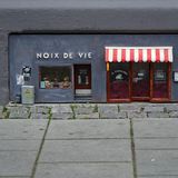 Damit fing es 2016 an, dem Café "Noix De Vie" und dem italienischen Käsegeschäft "Il Topolino". Rechts an der Wand der Hinweis auf das Schöpferduo