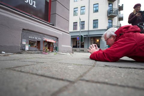 Ein Mann fotografiert die kleinen Mäuselokale in Malmö