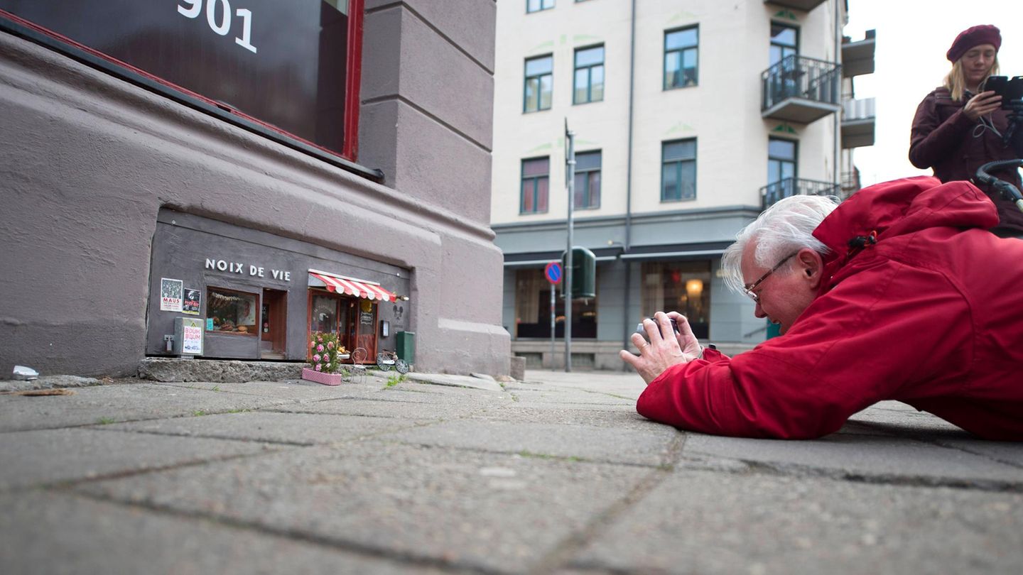 Ein Mann fotografiert die kleinen Mäuselokale in Malmö