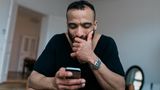 Mann schaut auf Handy
