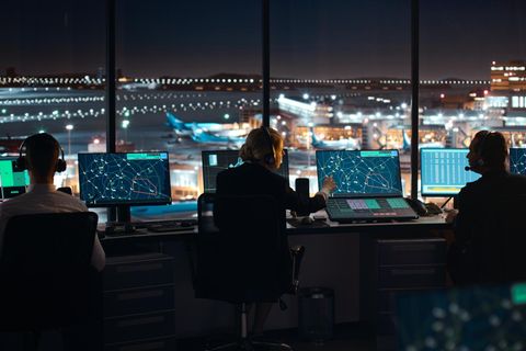 Flugsicherungspersonal im Tower am nächtlichen Flughafen