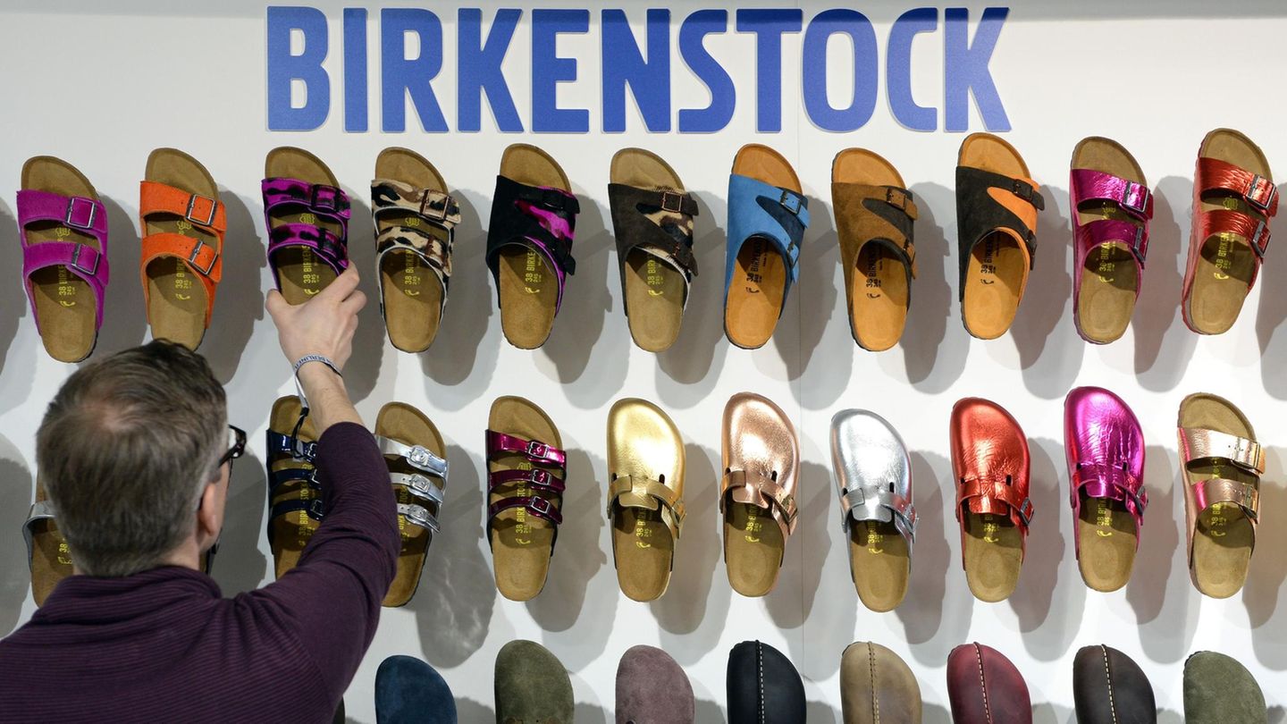 Ein Mitarbeiter sortiert Schuhe des Herstellers Birkenstock