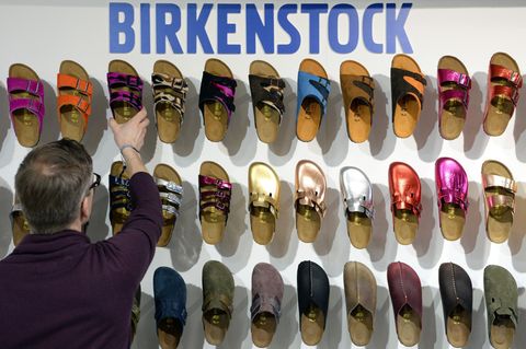 Ein Mitarbeiter sortiert Schuhe des Herstellers Birkenstock