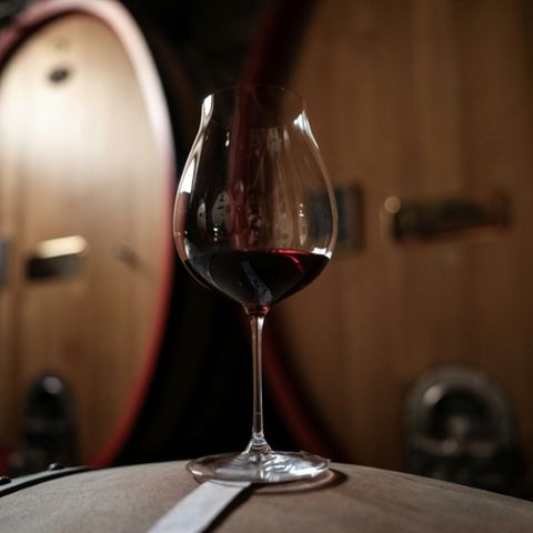 Glas Wein auf Holzfass
