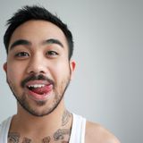 Junger Mann mit Zunge im Mundwinkel