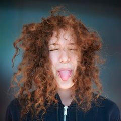 Junge Frau streckt ihre Zunge heraus