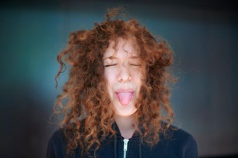 Junge Frau streckt ihre Zunge heraus