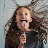 Mädchen mit Lupe vor der Zunge