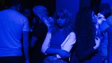 Party in Damaskus: Eine junge Frau steht gelangweilt im blauen Licht.