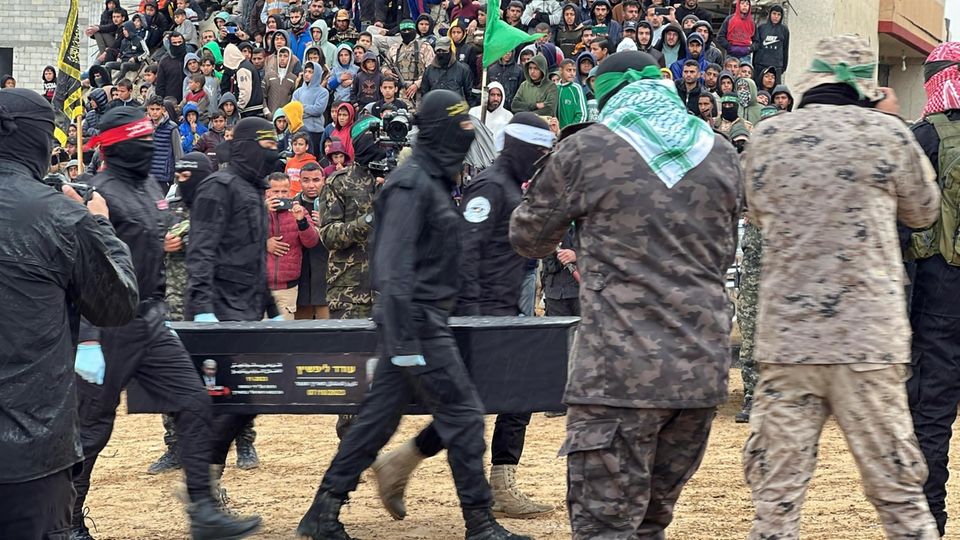Ein schwarzer Sarg wird von der Hamas an Israel übergeben