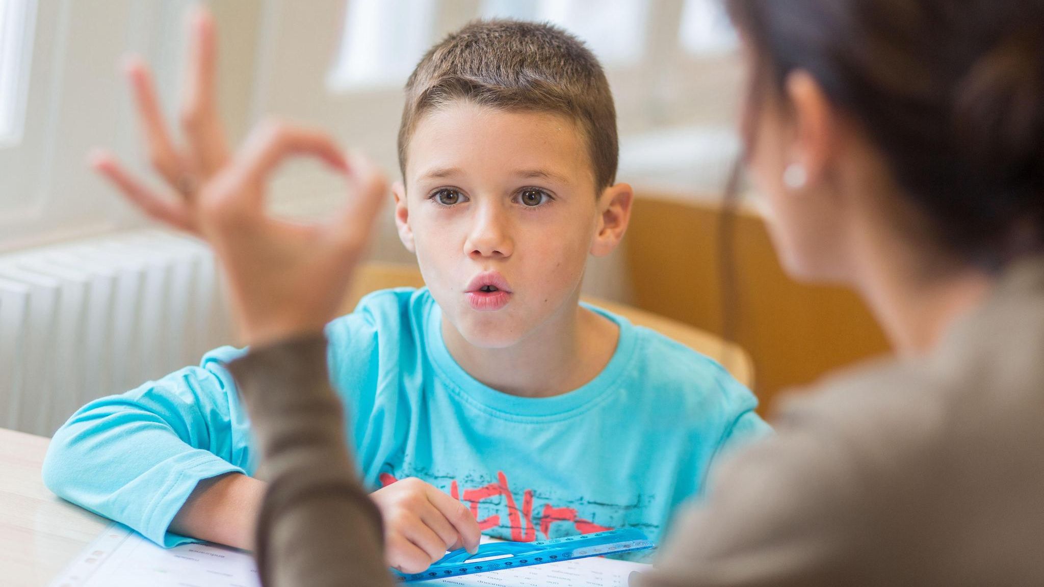 Eine Junge absolviert Sprechübungen mit einer Logopädin Eine Junge absolviert Sprechübungen mit einer Logopädin
