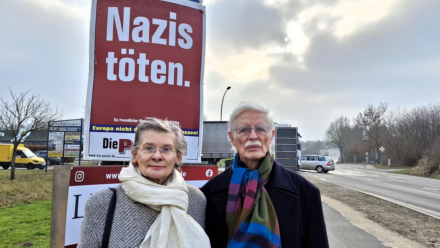 Das Eutiner Ehepaar steht vor dem Wahlplakat von "Die Partei", darauf steht: "Nazis töten."
