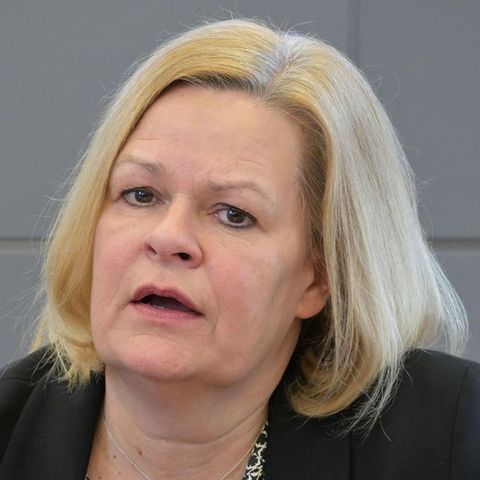 Bundesinnenministerin Nancy Faeser gestikuliert, während sie auf einem Podium in ein Mikro spricht