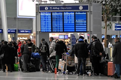 Menschen stehen am Flughafen in Düsseldorf und warten