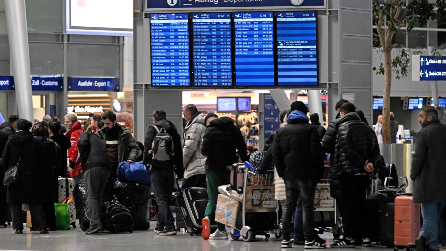 Menschen stehen am Flughafen in Düsseldorf und warten