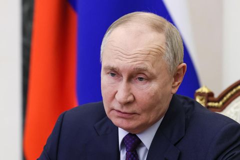 Russlands Präsident Wladimir Putin sitzt an einem Schreibtisch und gestikuliert