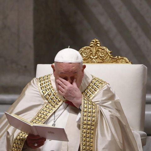 Papst Franziskus hält sich die Hand bei einer Messe vor das Gesicht