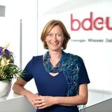 Kerstin Andreae steht im blauen Kleid vor dem bdew-Schriftzug