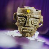 Eine Holzmaske, daneben Beutel mit weißem Pulver