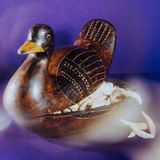 Eine Holzente, halb geöffnet, gefüllt mit Löwenzähnen