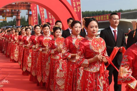Frauen und Männer in China bei einer Heirat in traditioneller Kleidung