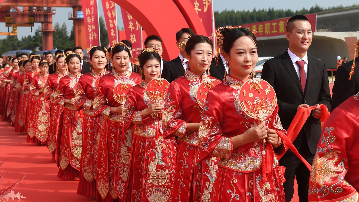 Frauen und Männer in China bei einer Heirat in traditioneller Kleidung