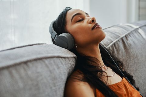 Ene Frau mit Kopfhörern genießt die Ruhe durch Noise Cancelling