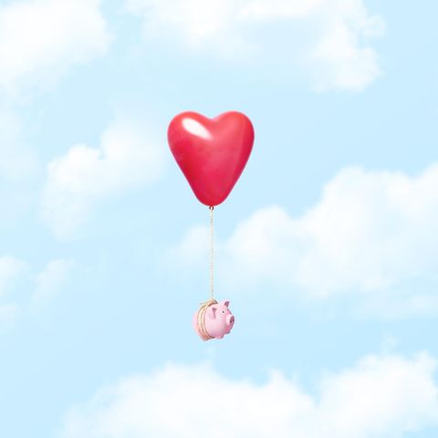Geld in der Beziehung: Ein am Herz-Luftballon hängendes Sparschwein