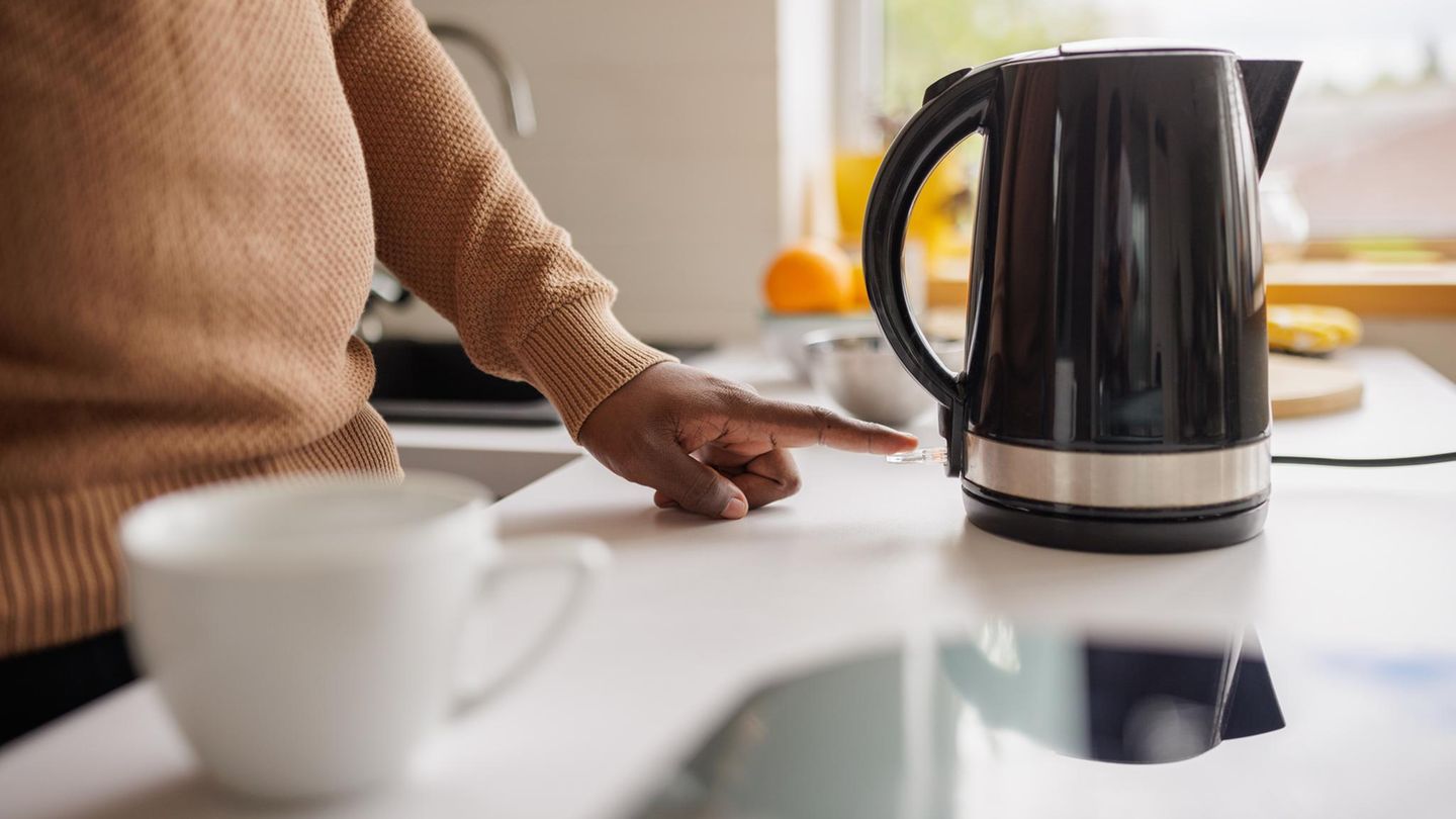 Wasserkocher im Warentest 2025 Person schaltet Wasserkocher an