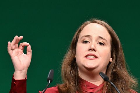 Ricarda Lang gestikuliert mit rechts, während sie auf einer Bühne eine Rede hält
