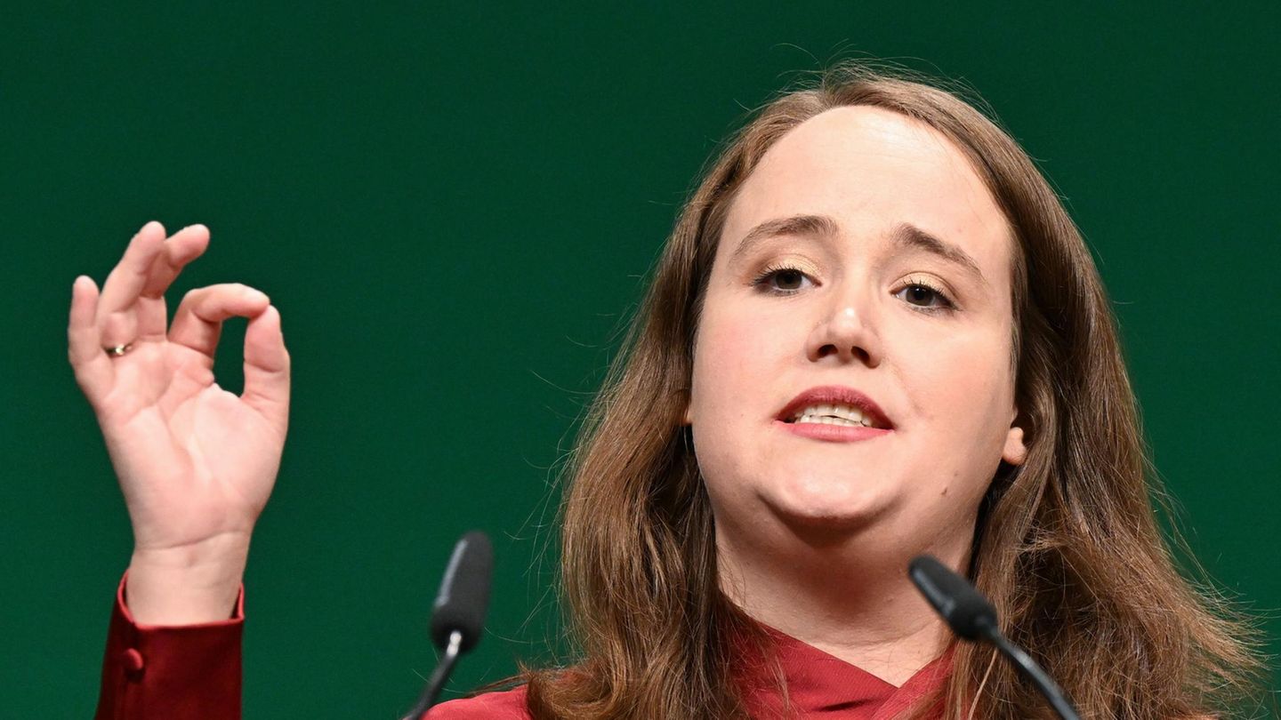 Ricarda Lang gestikuliert mit rechts, während sie auf einer Bühne eine Rede hält