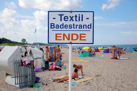 FKK Strand in Rostock Warnemünde. Auf einem Schild steht "Textil Badestrand ENDE"