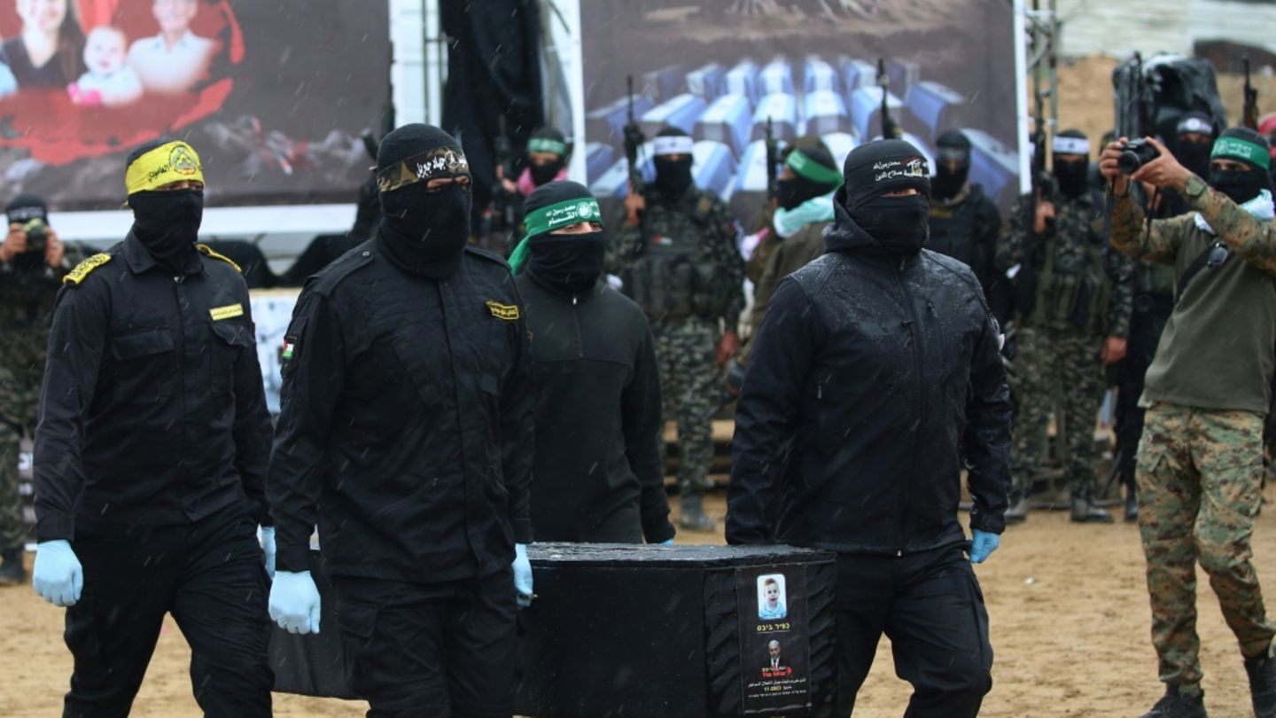 Hamas-Kämpfer bei der Übergabe toter israelischer Geiseln
