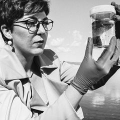 Paola Magni mit einem Glas, das eine Wasserprobe des Lago Bracciano enthält