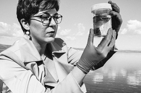 Paola Magni mit einem Glas, das eine Wasserprobe des Lago Bracciano enthält