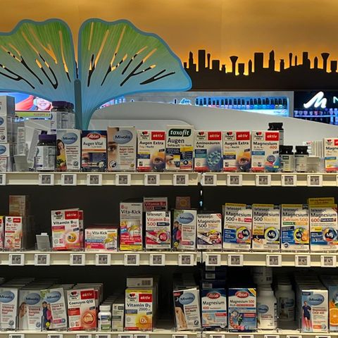 Drei Regalreihen mit Vitaminen und anderen Nahrungsergänzungsmitteln im Drogeriemarkt